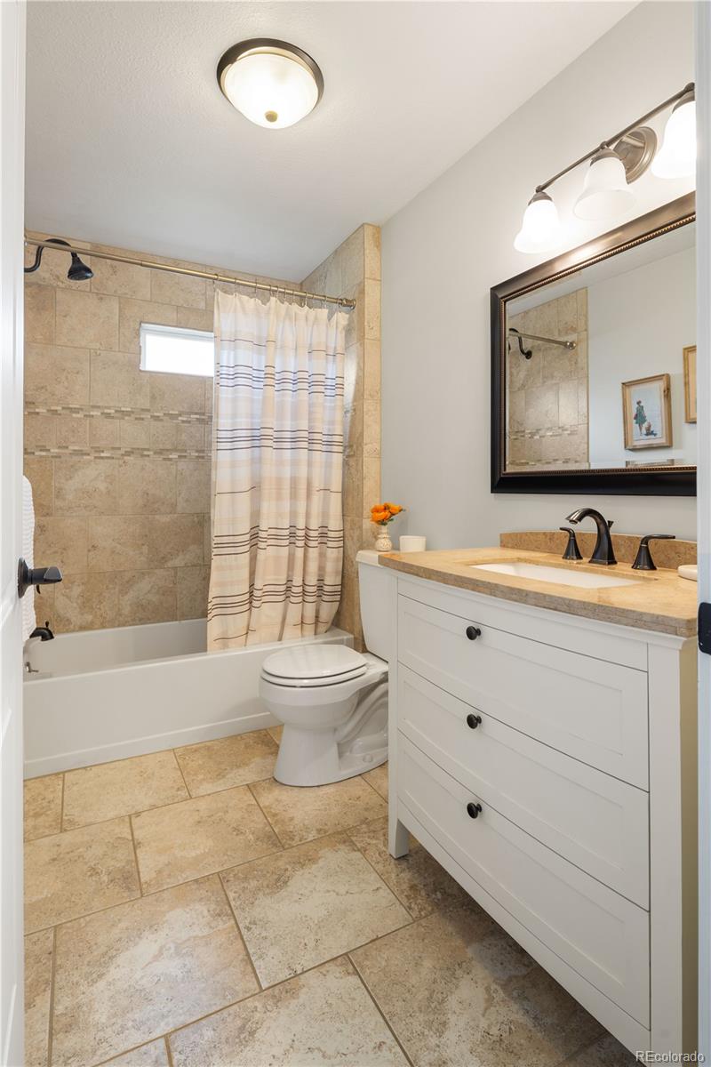 2242 North Lamar Street Edgewater, CO 80214 - Photo 17 of 27 a bathroom with a toilet sink and mirror