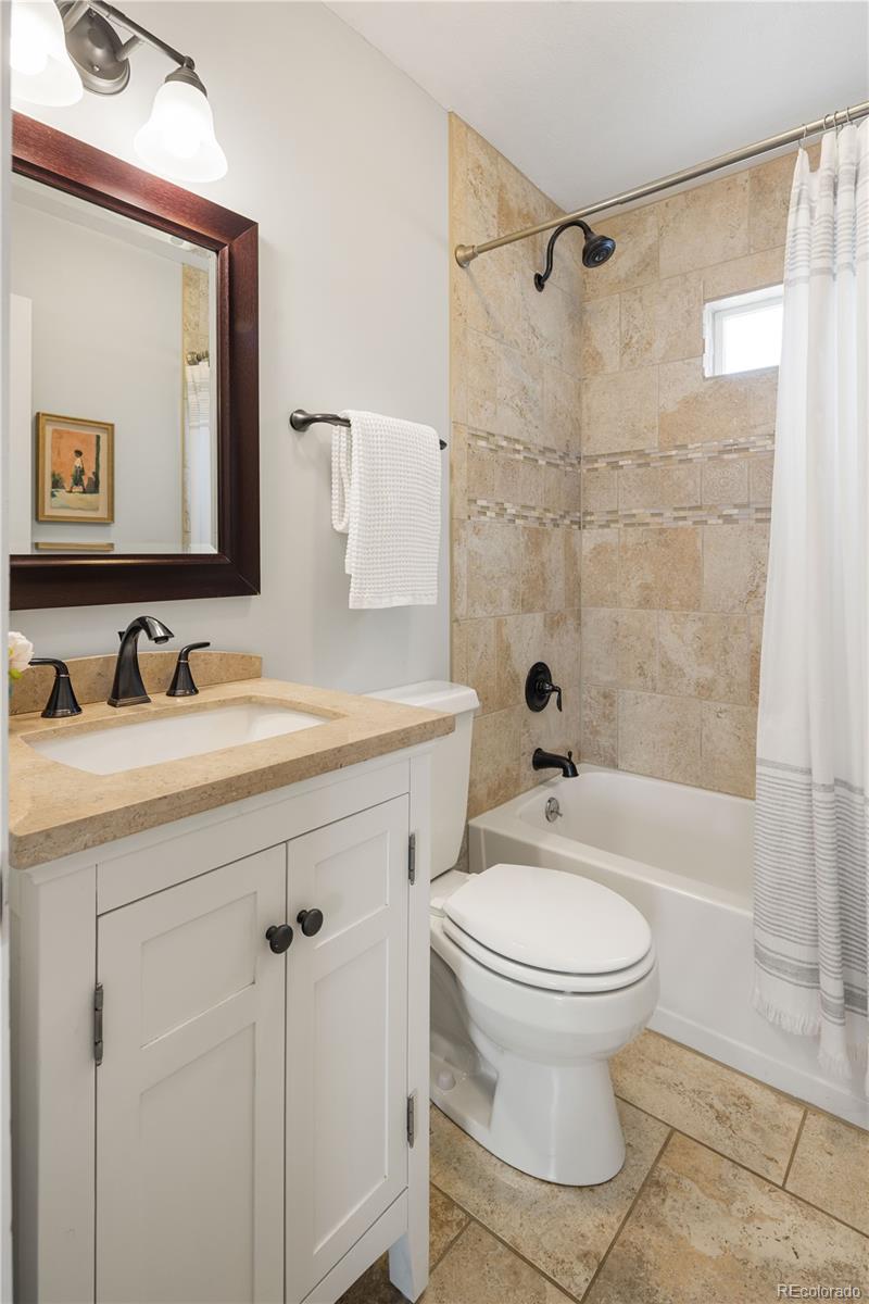 2242 North Lamar Street Edgewater, CO 80214 - Photo 20 of 27 a bathroom with a sink toilet a mirror and shower