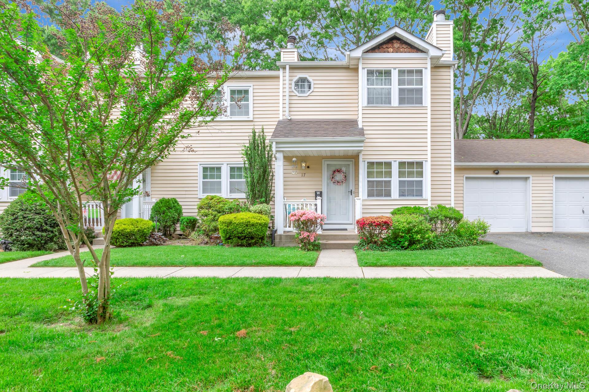 17 Stone Commons Yaphank, NY 11980 - Photo 4 of 31 Cream-colored vinyl siding exterior with white trim windows and a front entry porch