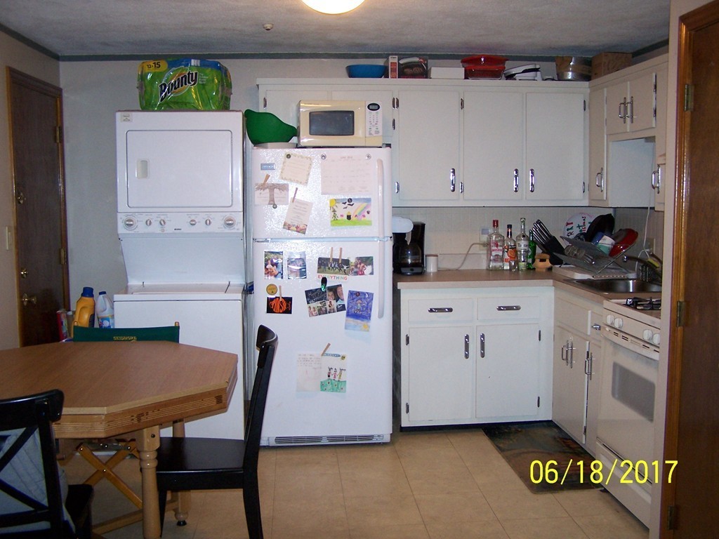 5 Kenmar Drive, Unit 18 Billerica, MA 01821 - Photo 4 of 10 a kitchen with stainless steel appliances a white refrigerator a stove a sink and white cabinets with wooden floor