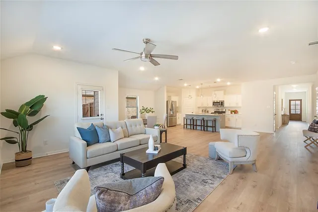 a living room with furniture and a wooden floor