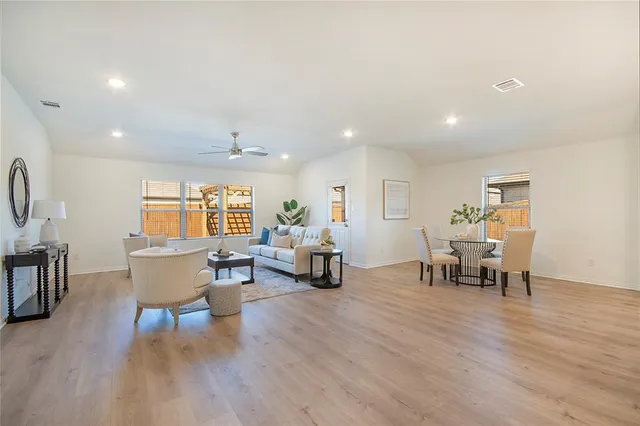 a living room with furniture and a wooden floor