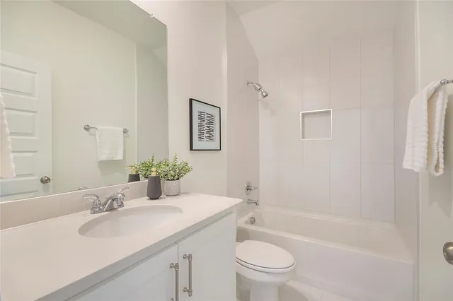 a bathroom with a granite countertop sink a toilet and shower