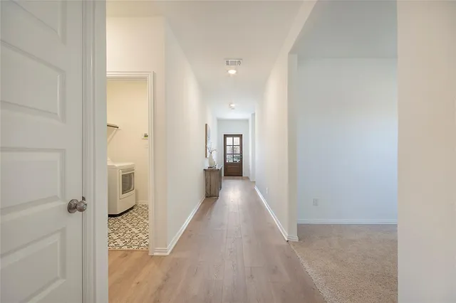 a view of a hallway with wooden floor and closet