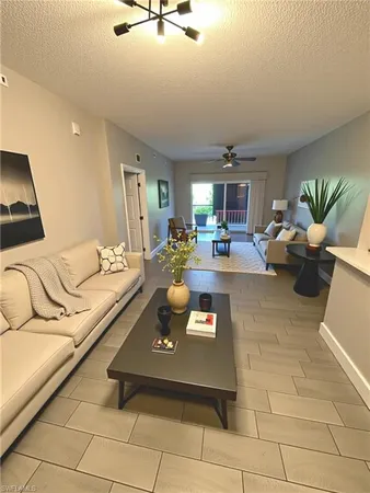 a living room with furniture and a dining table with kitchen view