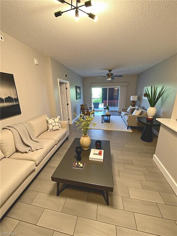 a living room with furniture and a dining table with kitchen view