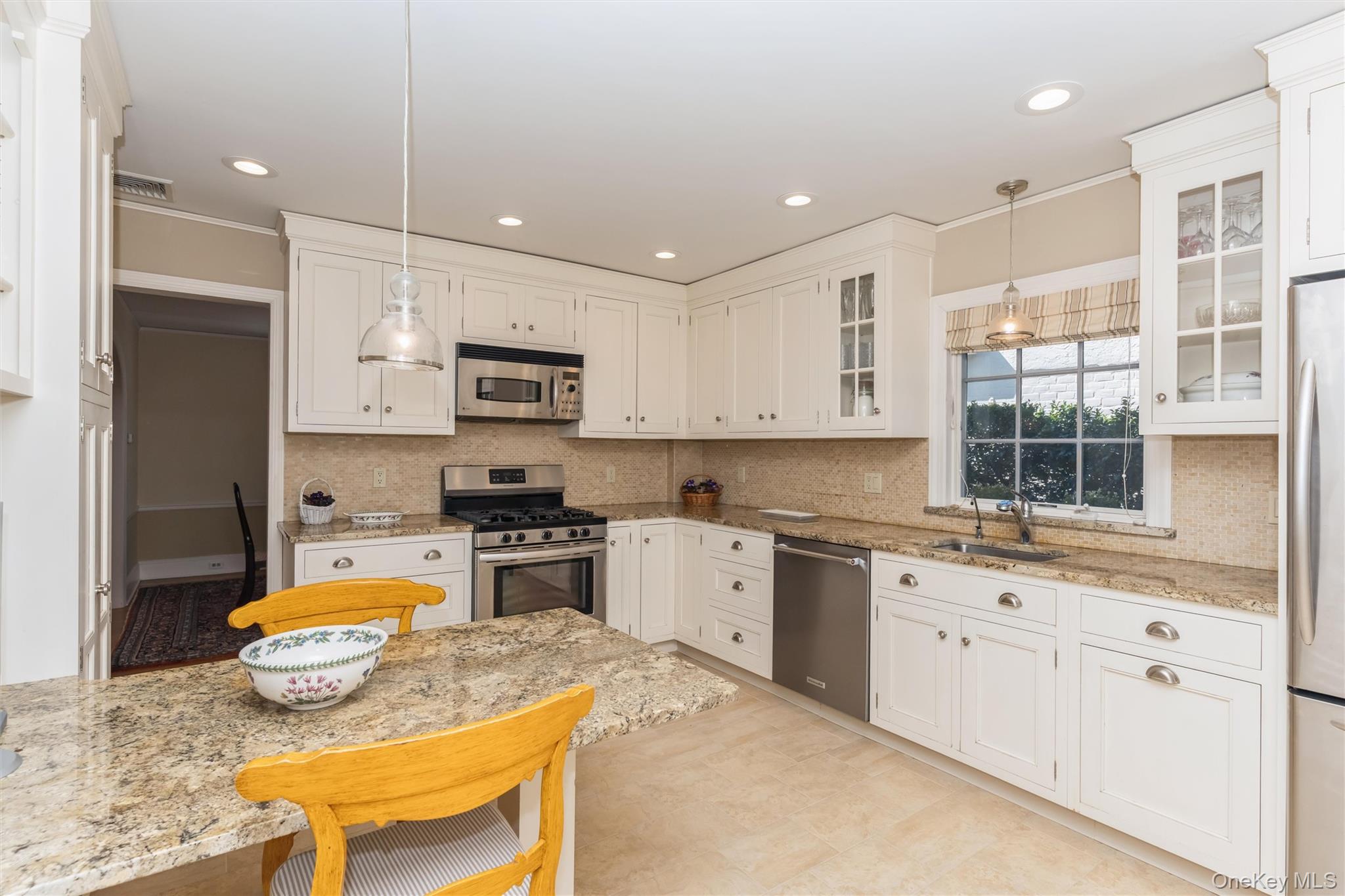 46 Wyatt Road Garden City, NY 11530 - Photo 11 of 32 a kitchen with granite countertop kitchen island stainless steel appliances a stove a sink a microwave a refrigerator and cabinets