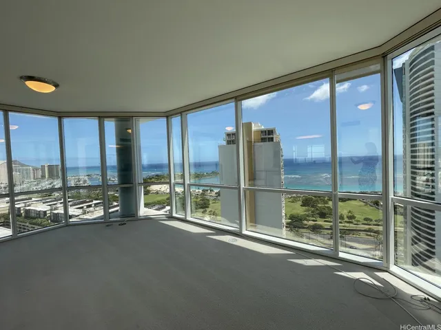 a view of an empty room with a large window and living room