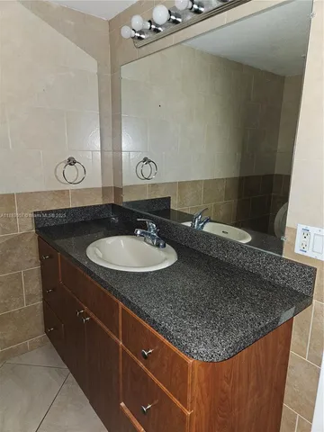 a bathroom with a granite countertop sink a mirror and vanity