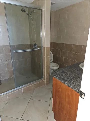 a bathroom with a granite countertop shower and a sink
