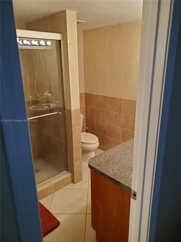 a bathroom with a granite countertop shower and a sink