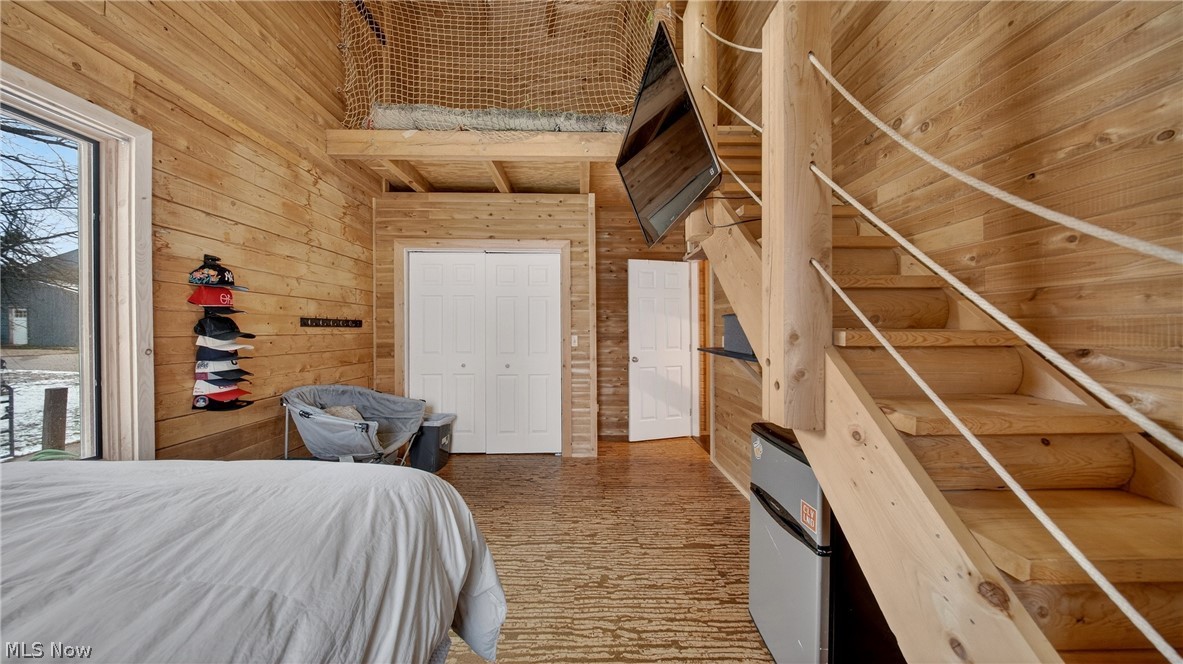1693 Middleton Road Hudson, OH 44236 - Photo 15 of 48 Bedroom featuring wood walls, a high ceiling, and a closet