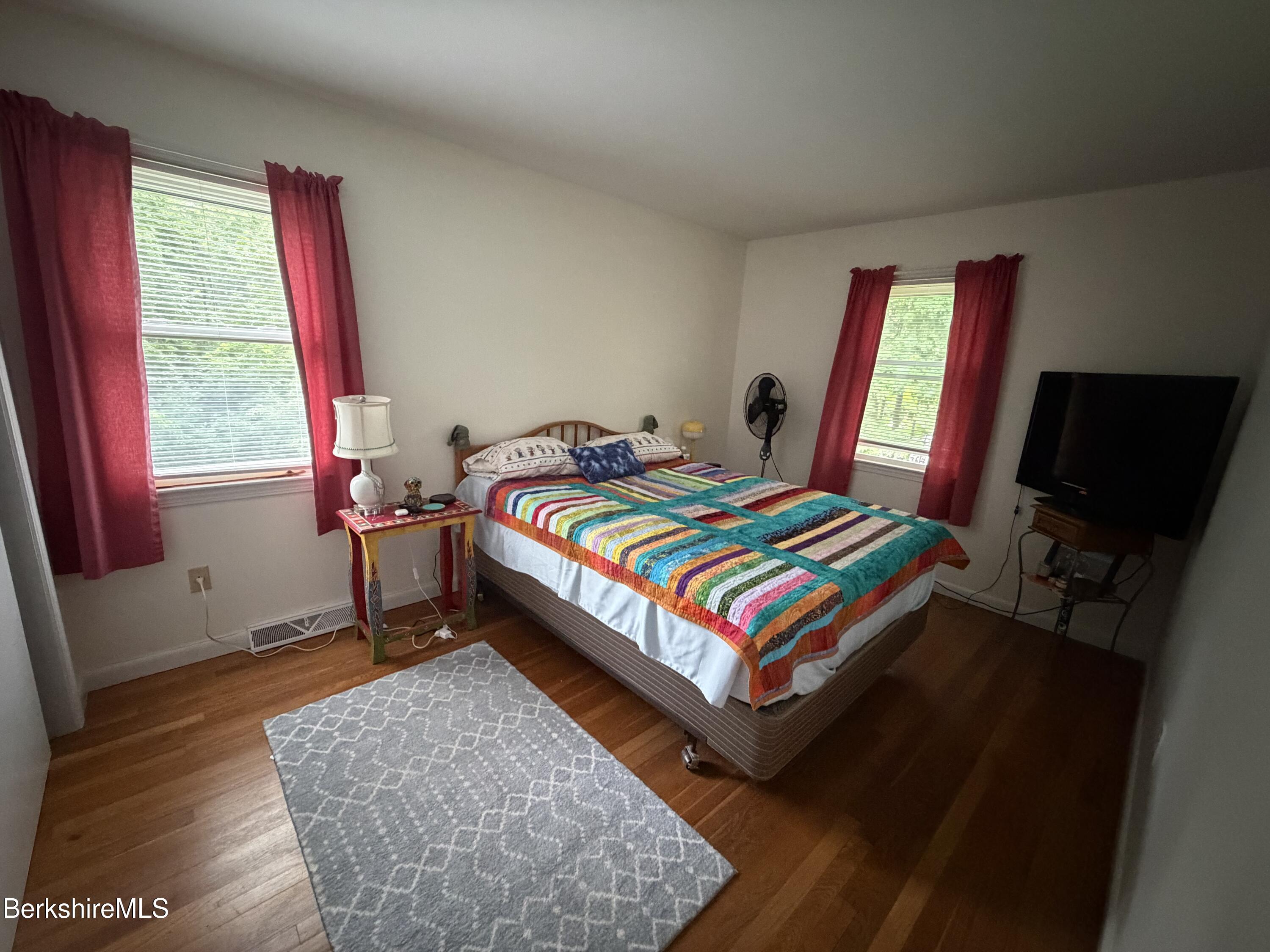 20 Sullivan Lane Lenox, MA 01240 - Photo 10 of 23 a bedroom with a bed a flat screen tv and windows