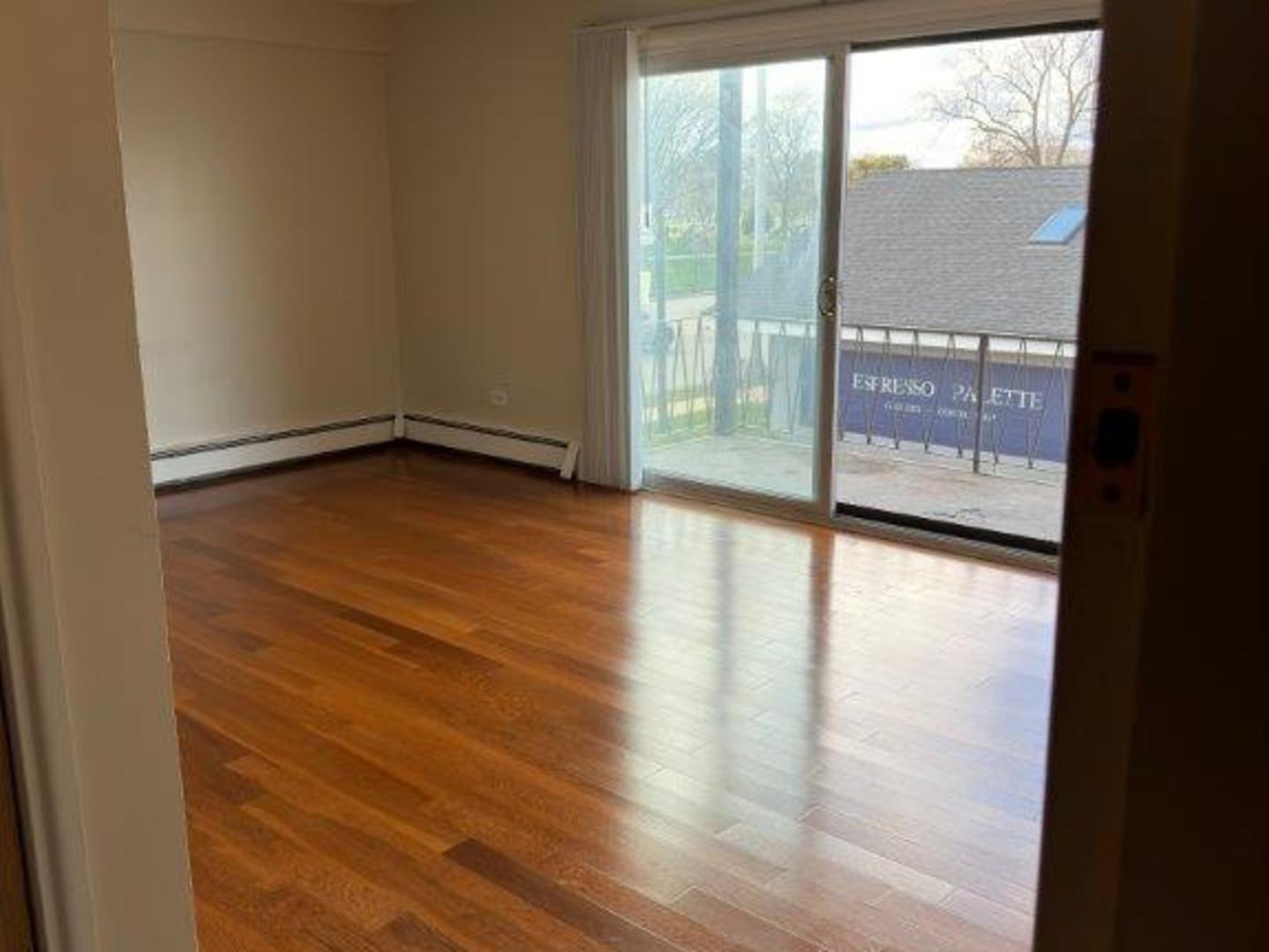 5724 West 111th Street, Unit 2B Chicago Ridge, IL 60415 - Photo 3 of 14 a view of an empty room with wooden floor and a window