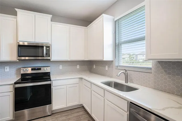 a kitchen with a sink stove and microwave