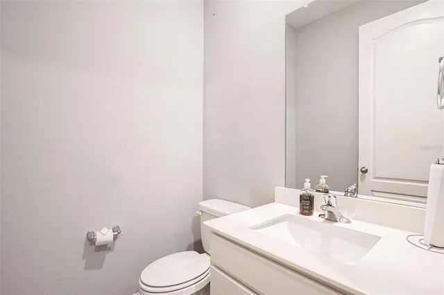 a bathroom with a sink vanity mirror and toilet