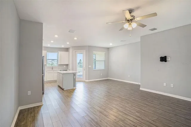 a view of a kitchen with a sink and dishwasher with wooden floor