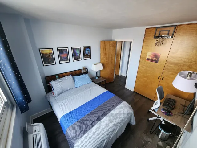 a bedroom with a bed and wooden floor