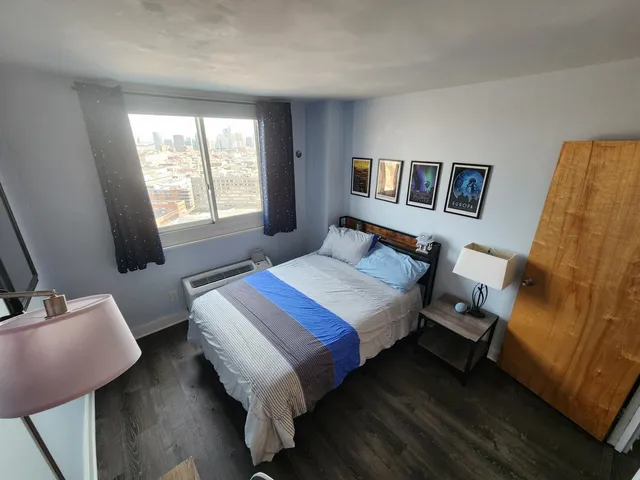 a bedroom with a bed and wooden floor