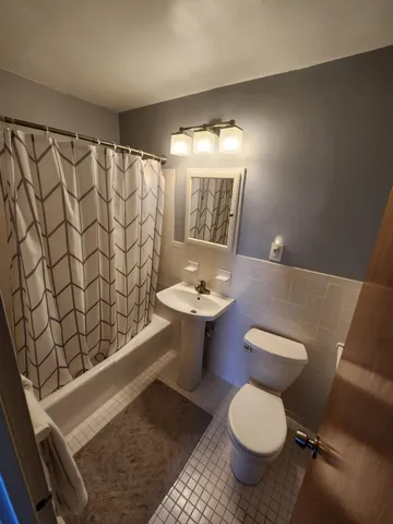 a bathroom with a toilet a sink and a mirror