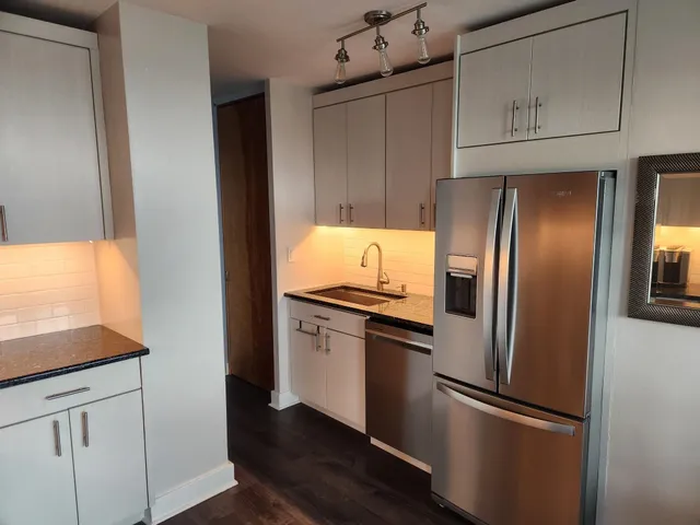 a kitchen with stainless steel appliances granite countertop a refrigerator and a stove