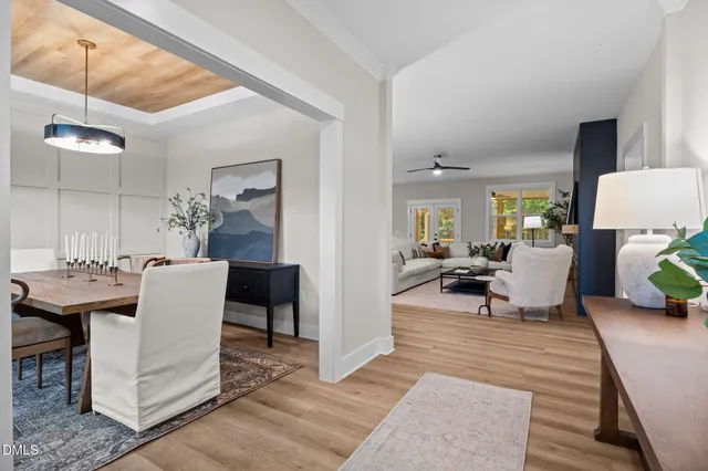 a dining room with furniture a potted plant and wooden floor