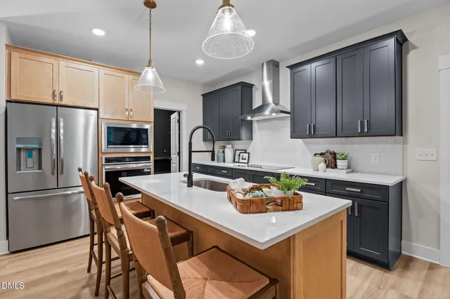 a kitchen with stainless steel appliances kitchen island granite countertop a sink wooden cabinets and a granite counter tops