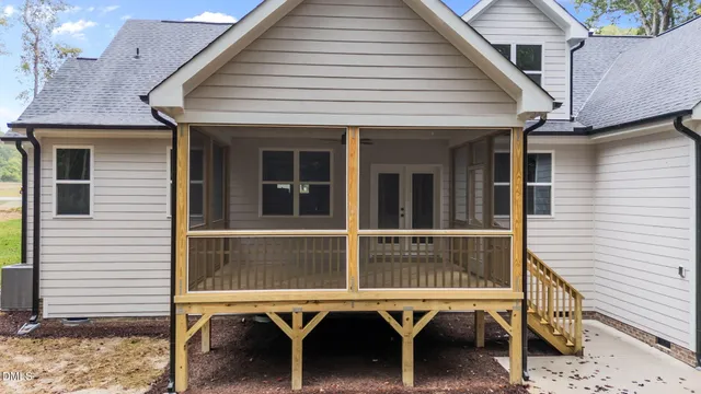a view of a house with a wooden door and a chair