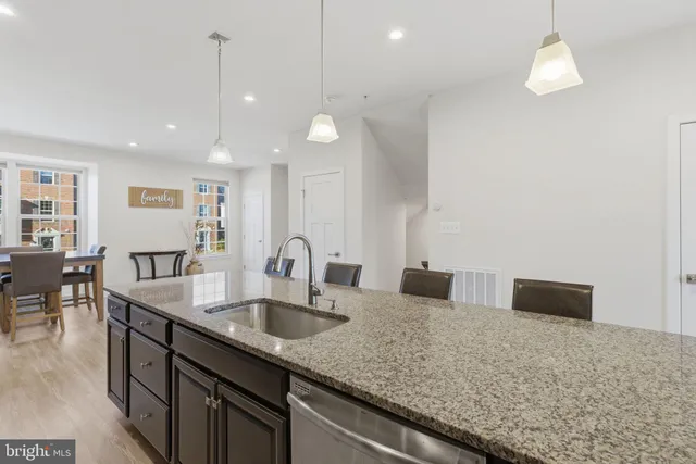 a kitchen with center island a sink stainless steel appliances and a counter top space