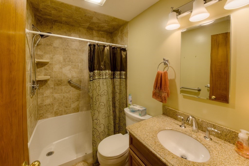 37 Endecott Street Springfield, MA 01118 - Photo 24 of 39 a bathroom with a granite countertop bathtub shower sink mirror vanity and toilet