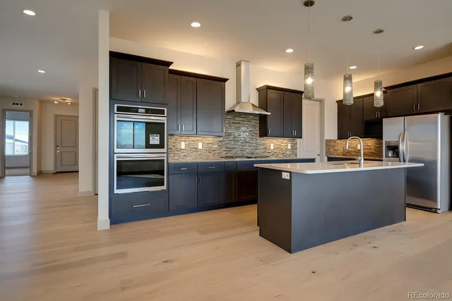 a kitchen with stainless steel appliances granite countertop a refrigerator and a stove