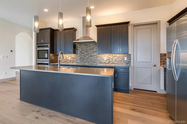 a kitchen with stainless steel appliances granite countertop a refrigerator and a sink