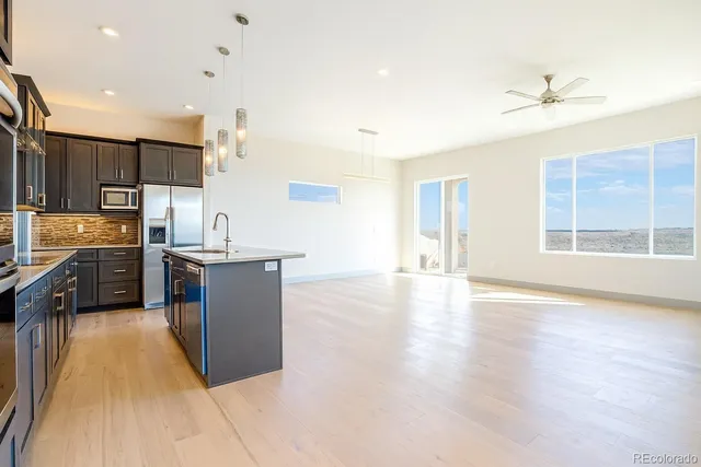 a kitchen with stainless steel appliances granite countertop a sink counter space cabinets and a large window