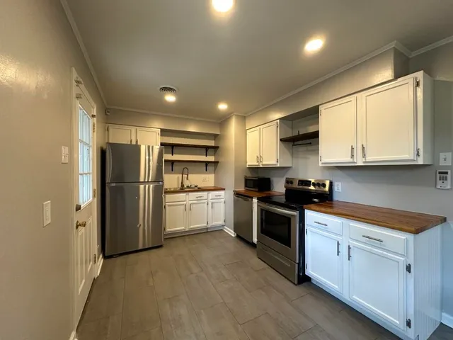 a kitchen with white cabinets and stainless steel appliances