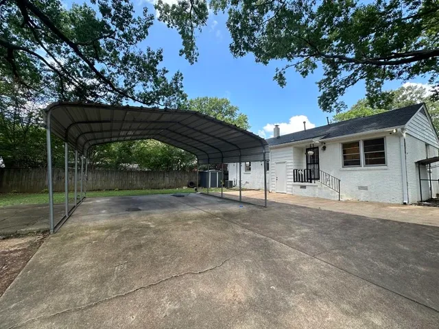 a view of a house with backyard and a tree