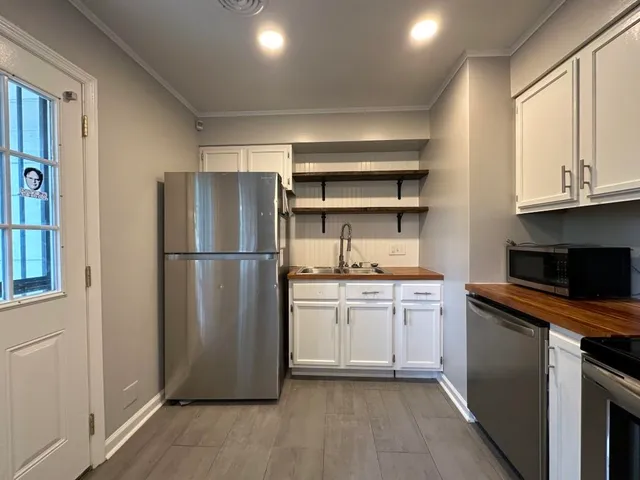 a kitchen with stainless steel appliances granite countertop a refrigerator a stove a sink and a microwave