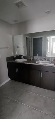 a kitchen with kitchen island granite countertop a sink and cabinets