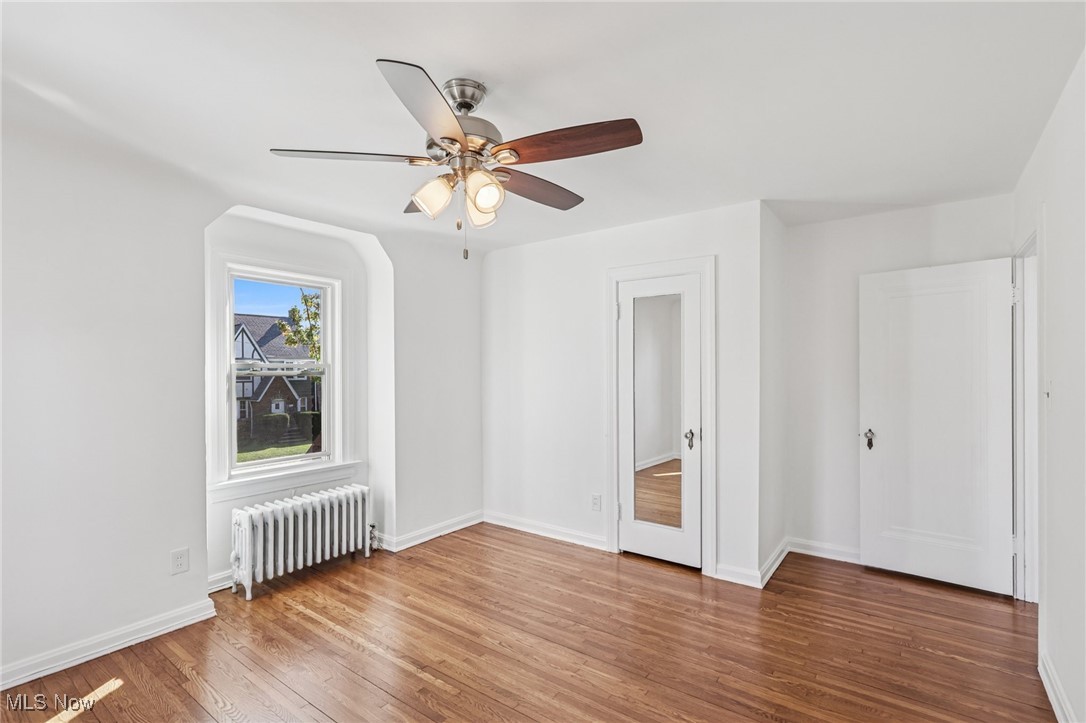 3621 Cedarbrook Road Cleveland, OH 44118 - Photo 23 of 40 Unfurnished bedroom with radiator heating unit, wood finished floors, and ceiling fan