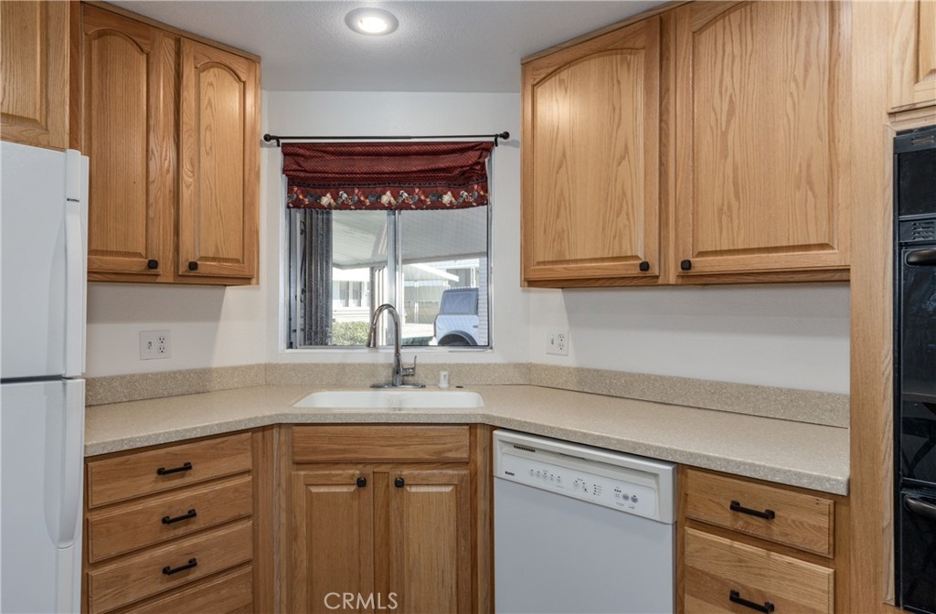 4133 West Wilson Street, Unit 168 Banning, CA 92220 - Photo 11 of 25 a kitchen with granite countertop cabinets and window