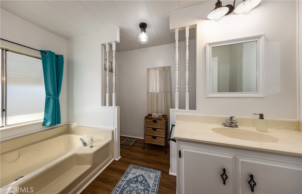 4133 West Wilson Street, Unit 168 Banning, CA 92220 - Photo 16 of 25 a bathroom with a tub sink and mirror