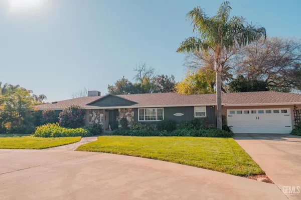a view of a house with a yard and potted plants