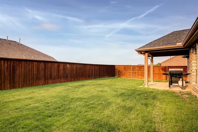a backyard of a house with table and chairs