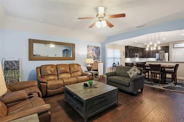 a living room with furniture kitchen view and a chandelier
