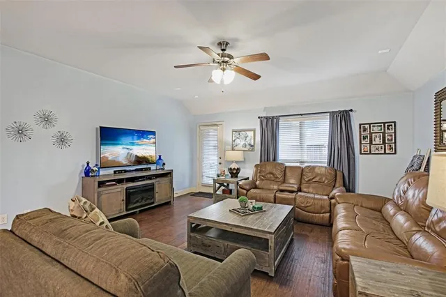 a living room with furniture a flat screen tv and a window