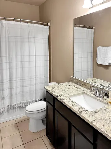 a bathroom with a granite countertop sink a toilet and a mirror
