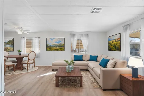 a living room with furniture wooden floor and a large window