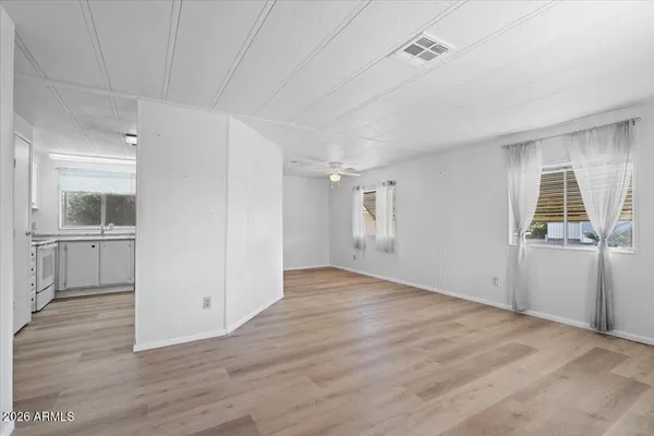 an empty room with wooden floor and windows