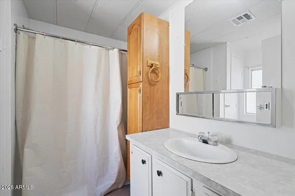 a bathroom with a granite countertop sink and a mirror