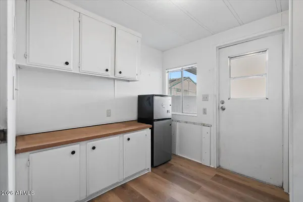 a room with white cabinets and white appliances