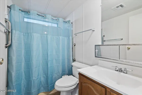 a bathroom with a sink a toilet a mirror and shower